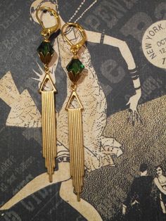 Textured Front, Hollow Back These Art Deco style earrings feature beautiful green Swarovski crystals and long stamped brass Deco style pendants. The brass pendants have a ribbed texture on the front and the hollow reverse on the back (SEE 2nd PHOTO). The earrings measure 3 1/4 inches long and hang from gold plated leverback ear wires. ABOUT THIS COLLECTION What are the three style essentials Jazz Age flappers like Clara Bow, Louise Brooks, and Zelda Fitzgerald have in common? Red lipstick, bobbe Vintage Gold Earrings For May Birthstone, Antique Green Clip-on Jewelry, Art Deco Gold Clip-on Jewelry, Vintage Brass Dangle Clip-on Earrings, Vintage Nickel-free Crystal Metal Earrings, Vintage Green Evening Jewelry, Vintage Brass Earrings For Evening, Antique Brass Earrings For Party, Formal Art Deco Clip-on Earrings