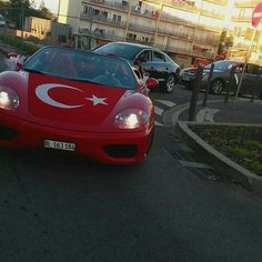 a red sports car is driving down the street