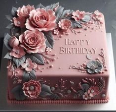 a pink birthday cake with flowers on it