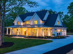 a large white house with lots of lights on it's windows and front porch