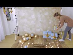 a woman is decorating presents on the floor with candles and lights in front of her