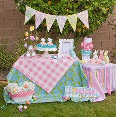 a table set up for an easter party with bunnies, cake and other decorations