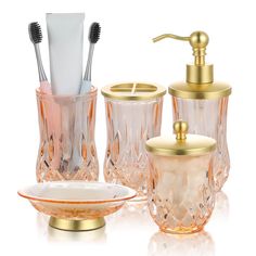 an assortment of bathroom accessories including toothbrushes, soap dispenser and glass dishes