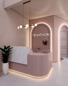 a pink and white reception area with marble counter top, potted plant and arched doorway