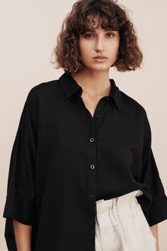 If you were to purchase one piece from our collection we would always say to start with our Lula Shirt. The Lula Shirt can be worn a number of different ways and has quickly become a Posse favourite. Made from a delicate cotton/linen blend, it has an oversized fit that's emphasized by it's billowy hem. Lightweight and versatile, this shirt is easy to wear and has an effortless, breezy feel to it. We have no doubt it will quickly become one of your most cherished wardrobe staples and your best fr Black Linen Shirt For Spring, Effortless Black Cotton Top, Effortless Long Sleeve Black Tops, Black Relaxed Fit Shirt For Daywear, Black Linen Tops For Workwear, Black Tops With Shirttail Hem For Daywear, Black Linen Top For Workwear, Chic Black Shirt For Daywear, Spring Daywear Black Shirt