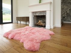 a living room with a pink rug and fireplace