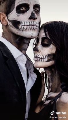 two people dressed in skeleton makeup are posing for the camera with their faces painted white and black