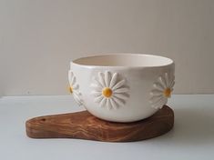 a white bowl sitting on top of a wooden stand