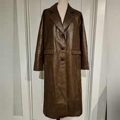 Sleek, Straight Line, Button Down Faux Leather Coat With Pinched Pleats By Dept. Anonym, In A Rich Chocolate Brown. Midi/Calf-Length Features Front Flap Pockets Pinched Pleats (Front & Back) Button Down Straight Fit Lined 50% Polyurethane 50% Polyester Size Small Flatlay Measurements (Buttoned): Pit To Pit: 23" Sleeve: 22" Length: 45" Shoulder Width (Seam To Seam): 20" Waist: 23" New With Tags Please See Actual Product Photos For Garment Color/Detail, Which May Vary From Stock Photos. Note: Coat Brown Long Coat For Office, Brown Long Coat With Snap Buttons, Brown Leather Long Coat For Fall, Brown Button-up Leather Jacket For Fall, Brown Buttoned Outerwear For Office, Brown Office Outerwear With Buttons, Brown Faux Leather Outerwear With Button Closure, Brown Leather Jacket With Buttons For Fall, Chic Brown Outerwear With Double Button Closure