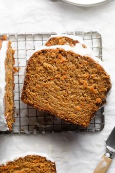 sliced carrot cake on a cooling rack with one slice cut out and the other half eaten