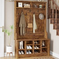 a wooden coat rack with shoes and coats hanging on it's sides next to a stair case