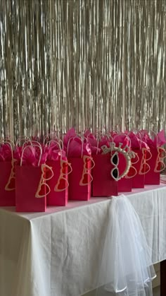 pink bags with the number eight on them are sitting on a table in front of a curtain