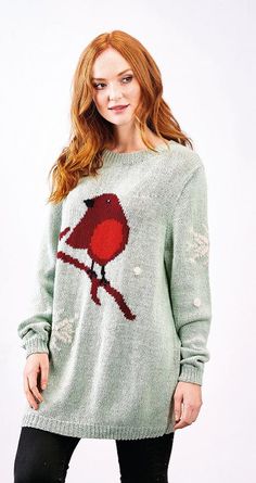 a woman wearing a green sweater with a red bird on the front and white background