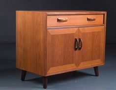 a wooden cabinet sitting on top of a gray floor