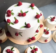 a white cake with raspberries on it