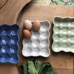 three bowls with eggs in them and lettuce on the table next to them