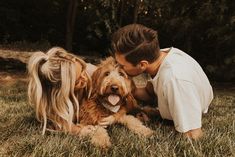 a man and woman laying in the grass with their dog, who is sticking his tongue out