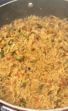 a pan filled with rice and vegetables on top of a stove