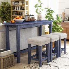 a dining table with four stools in front of it and a shelf full of books