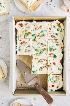 a cake in a box with white frosting and sprinkles on it