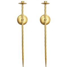 a pair of gold - plated metal candlesticks with two balls on them