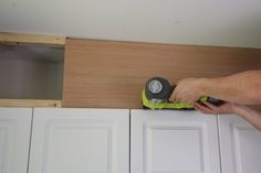 a person using a sander on some cabinets