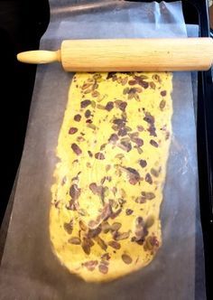 an uncooked dough on a baking sheet with a rolling pin