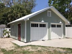 a white garage with two doors and windows