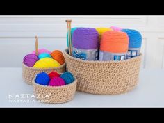 crochet baskets with yarn and knitting needles in them sitting on a white table