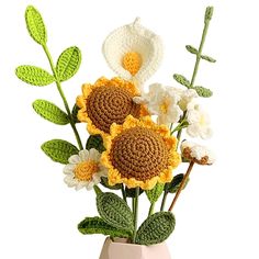 a crocheted flower arrangement in a vase on a white background with green leaves