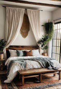 a large bed sitting in a bedroom next to a window with drapes on it