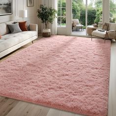 a living room with a pink rug on the floor next to a couch and chair