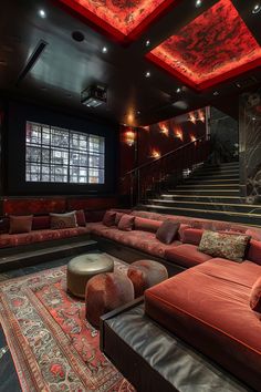 a living room filled with lots of red couches next to a stair case in front of a window