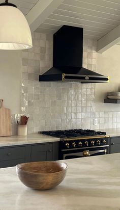 a bowl sitting on top of a kitchen counter next to an oven and range hood