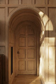 an arched wooden door in the middle of a room