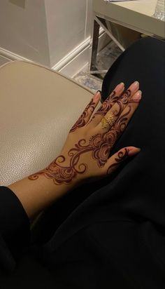 a woman's hand with henna tattoos on her left arm and the wrist