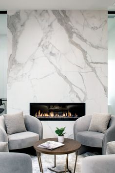 a living room filled with furniture and a fire place in the wall above it's fireplace