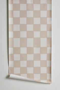 a beige and white checkered paper hanging on a wall