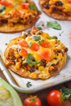 some taco pizzas are sitting on a tray