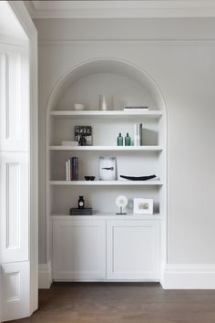 a white book shelf with books and other items on it