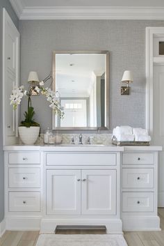 a white bathroom with two sinks and a large mirror over it's vanity area