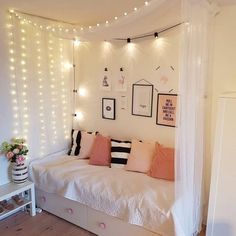 a bedroom with white walls and string lights