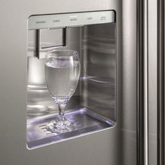 an empty glass is in the door of a stainless steel refrigerator