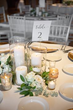 the table is set with candles, flowers and place cards for guests to sit at