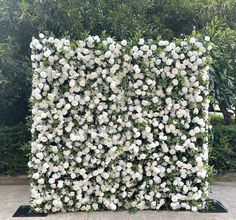 white flowers are arranged in the shape of a square planter on a black stand