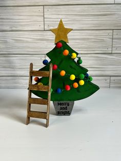 a small christmas tree sitting next to a ladder