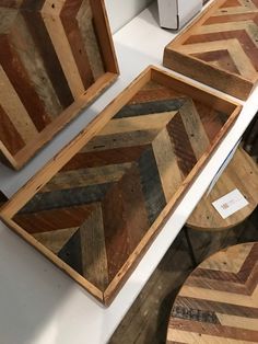 three wooden trays sitting next to each other on a white counter top in a room