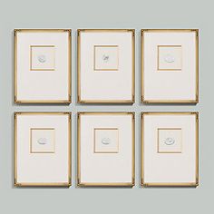 four framed pictures on a wall with white and gold trim