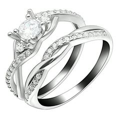 two white gold wedding rings with diamonds on each band and an oval cut diamond in the center