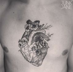 a black and white photo of a heart with flowers on it's side chest